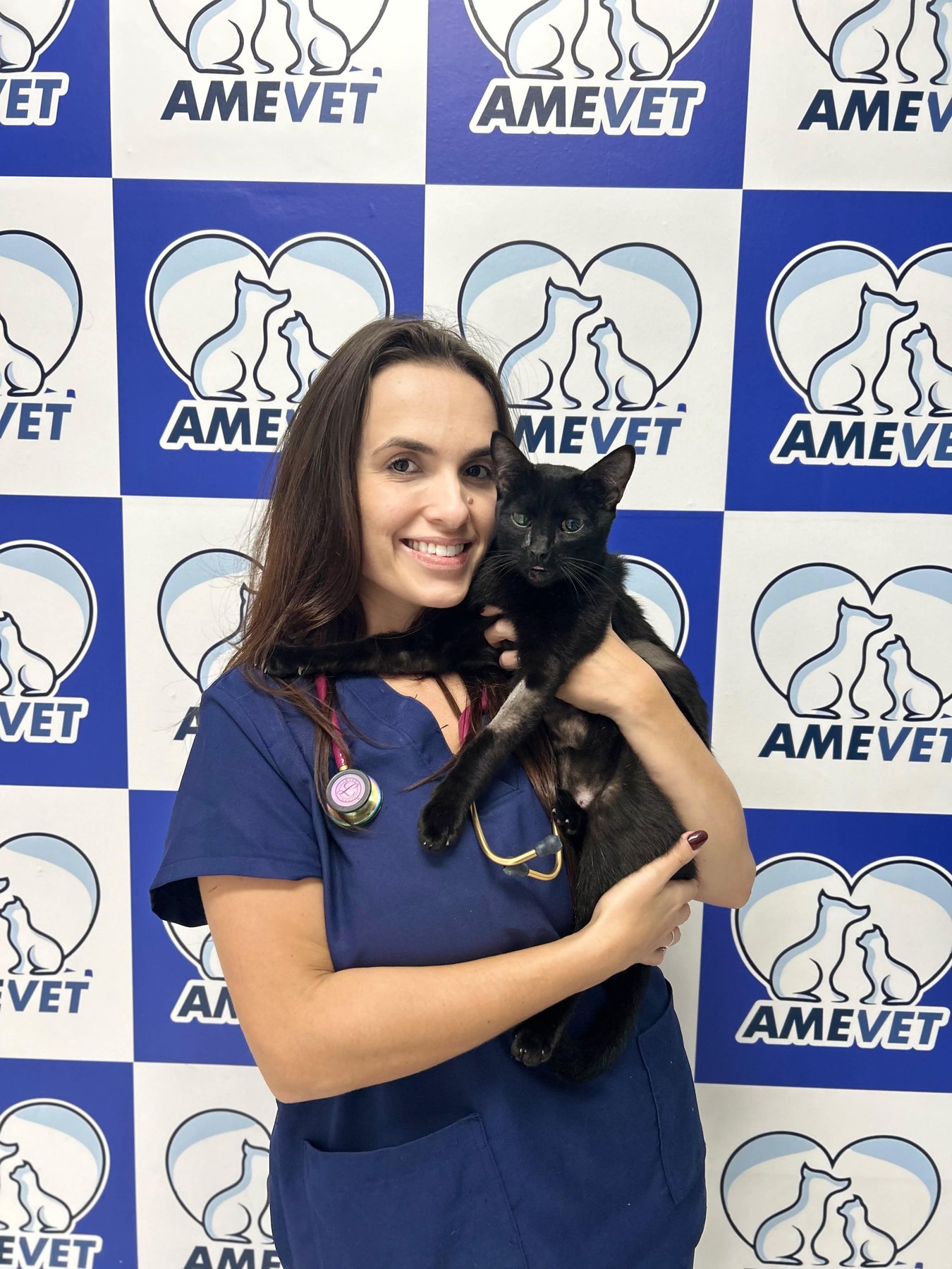 Veterinária da AMEVET segurando um gato preto